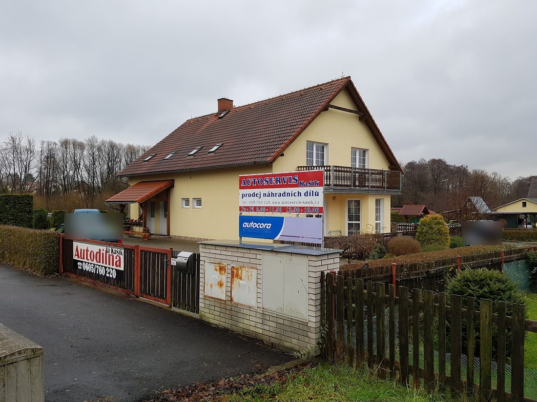 Žlutý rodinný dům s cedulí Autoservis Kašík, prodej náhradních dílů, u vjezdu cedule Autodílna